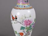 un vase blanc orné d'un oiseau et de fleurs