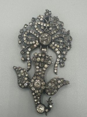 une image représentant une broche ornée d'une fleur et de feuilles