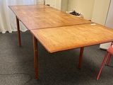 une table en bois avec une chaise rouge devant