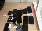 many cell phones on a table with a laptop on it