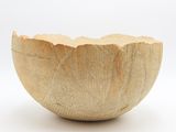 un bol en bois posé sur une surface blanche