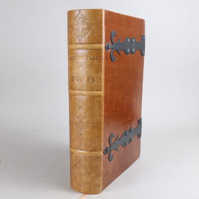 un vieux livre à la couverture en cuir posé sur une surface blanche