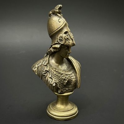 un buste en bronze représentant un homme coiffé d'un casque, posé sur un socle