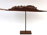 an image of a wooden sculpture of a leaf on a stand