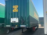 a large green semi truck parked in a parking lot