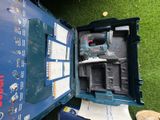 une boîte bleue contenant un outil, posée sur l'herbe