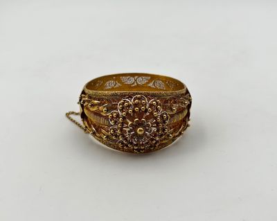 gros plan d'une bague en or sur une surface blanche
