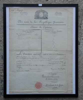 an old document with a red stamp on it is hanging on a wall