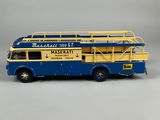 a blue and yellow double decker bus on a gray background
