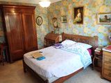 une chambre avec un lit, des commodes et des tableaux accrochés au mur