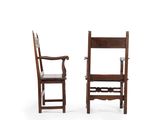 pair of antique wooden chairs with arms and backrests