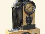 une statue de femme assise au sommet d'une horloge