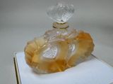 a glass perfume bottle on a white box on a table