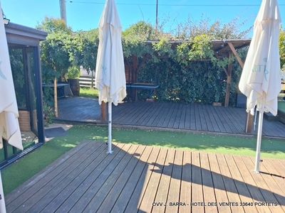 a wooden deck with umbrellas on it and a bench in the background