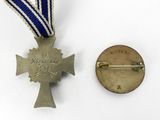 a medal and a medal pin on a white surface
