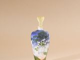a small glass vase with a flower inside of it