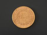 a close up of a gold coin on a black surface