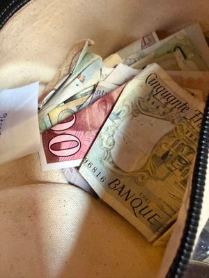 beaucoup d'argent dans un sac d'où sort un bout de papier
