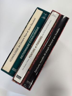 trois livres sont empilés sur une table
