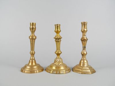 trois bougeoirs en or posés les uns sur les autres sur une table