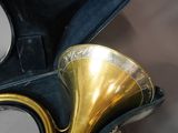 un instrument à vent en laiton dans un étui, avec un miroir en arrière-plan