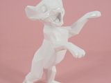 une figurine représentant un chat blanc debout sur ses pattes arrière