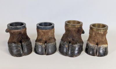 trois petits vases ornés de griffes, posés sur une table