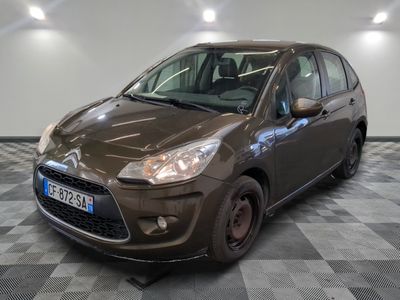 une photo d'une petite voiture marron garée dans un garage