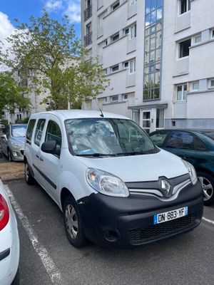 a white van parked in a parking lot next to other cars