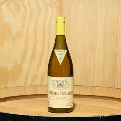 a bottle of wine sitting on top of a barrel