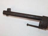 an old gun with a wooden handle on a white surface