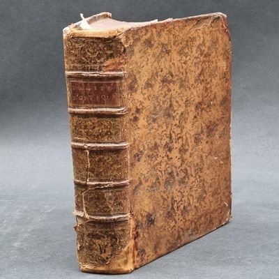 an old book sitting on top of a table next to a gray background