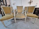 four chairs with upholstered cushions in a room with a white brick wall
