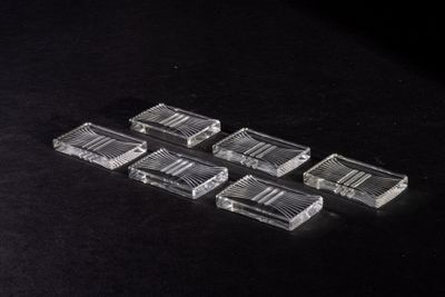 six pieces of clear plastic sitting on top of a black surface