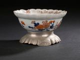 a white bowl with orange and blue flowers on it