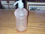 une bouteille en plastique munie d'une pompe, posée sur une table en bois