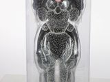 a black and silver teddy bear in a clear box