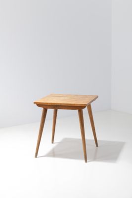 a small table with a wooden top on a white floor