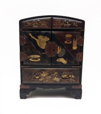 une commode noire et dorée sur fond blanc