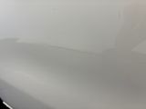 the front bumper of a white car with scratches on it