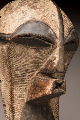 gros plan sur une sculpture en bois représentant le visage d'un homme