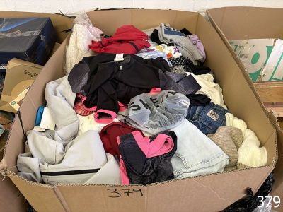 a cardboard box filled with clothes and other items