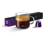 a cup of coffee next to a box of coffee capsules