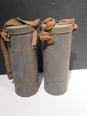 Il s'agit de deux vieilles boîtes en métal auxquelles est noué un ruban marron.