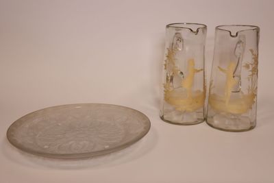 deux verres et une assiette posés sur une table à côté d'une pièce de monnaie