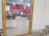 un grand miroir au milieu d'une pièce, avec une chaise à côté