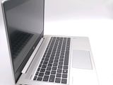 a silver laptop computer sitting on a white surface