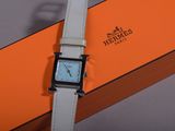 an orange and white box with a watch sitting on top of it