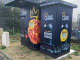 deux cartons sur lesquels sont dessinées des pizzas, posés sur le bord de la route