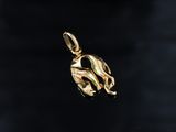 a gold plated elephant charm hanging from a black background